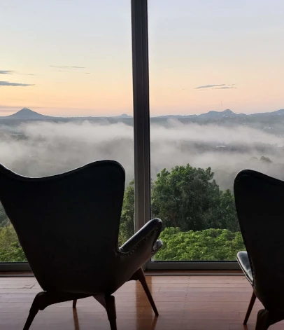 Two chairs looking across a tranquil sea of mist.